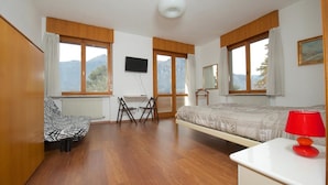 A bedroom with a bed, a desk, a chair, and a TV. - B&B Marzola (Trento)
