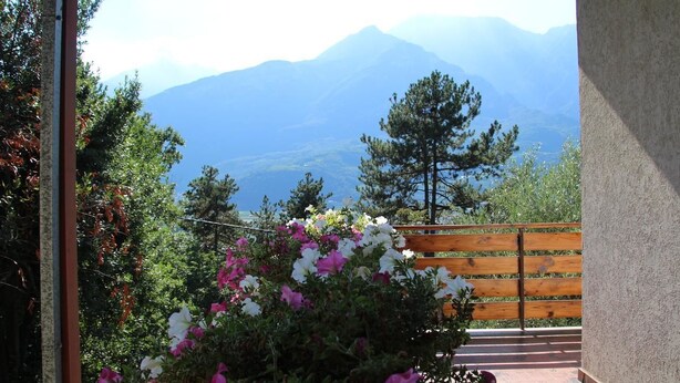 A balcony with a wooden railing overlooking a mountainous landscape. - B&B Marzola (Trento)