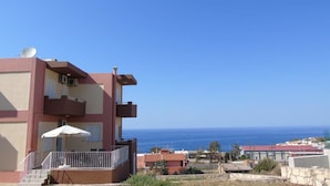 Ein mehrstöckiges Gebäude mit Balkonen, einer Satellitenschüssel und Blick aufs Meer.