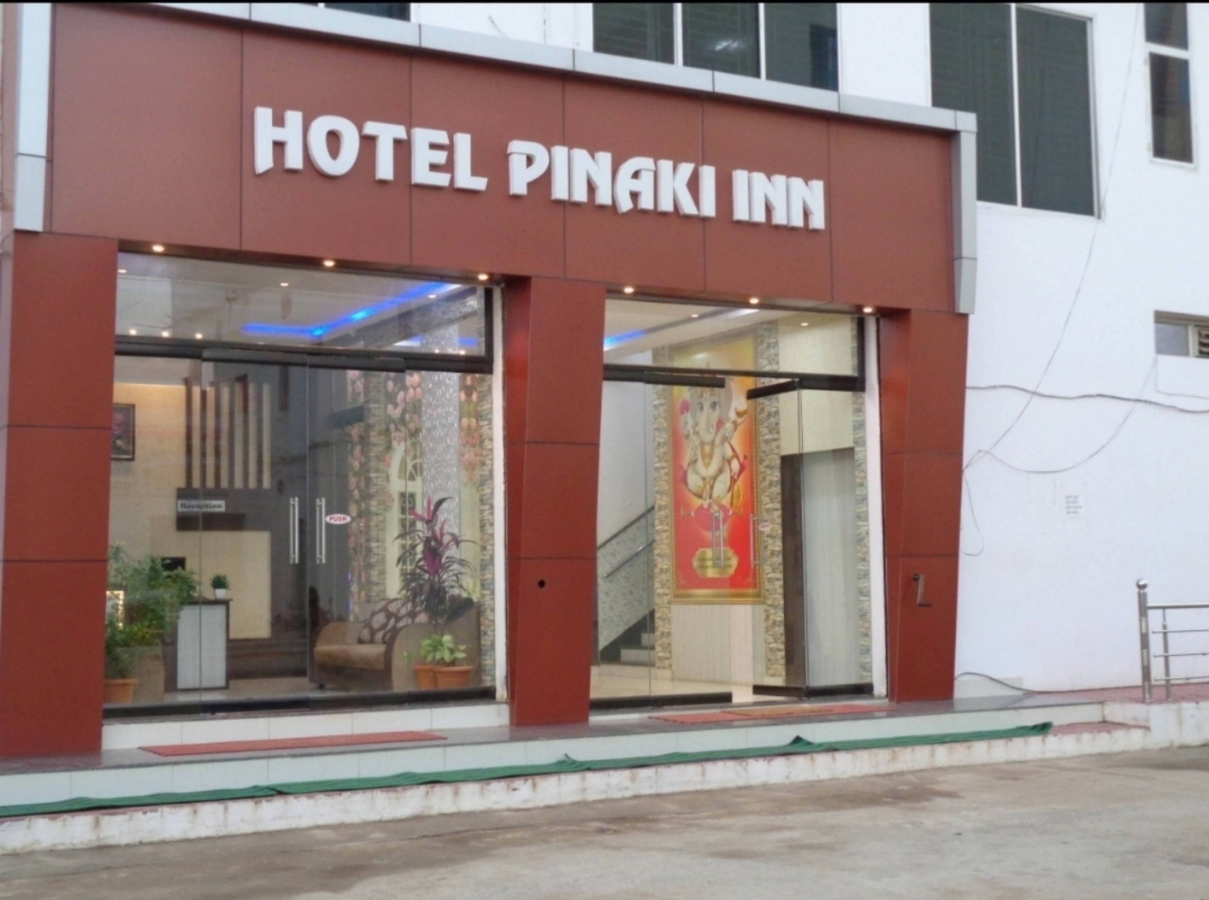 Ein Hotel namens "Hotel Pinaki Inn" mit einem Empfangsbereich, der durch die Glastüren sichtbar ist.
