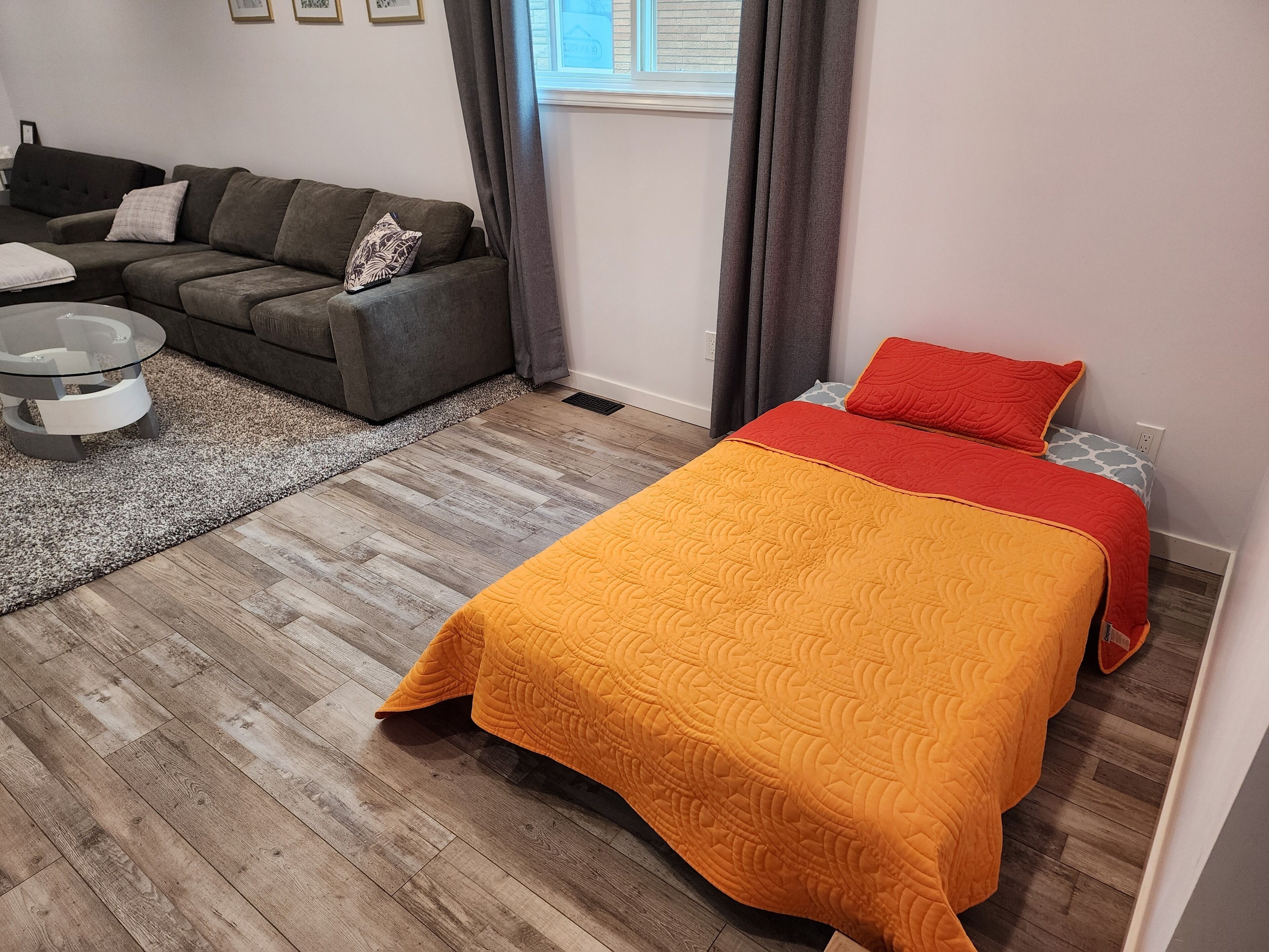 A bedroom with a bed, a sofa, and a coffee table.