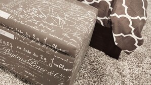 A bedroom with a patterned bedspread, pillows, and a bedside table with a decorative item. - Walk to the Falls & Attractions!
Modern, clean & comfortable 4 bedroom house (Niagara Falls)