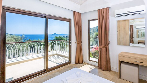 Ein Hotelzimmer mit Balkon, Bett, Bad und Meerblick.