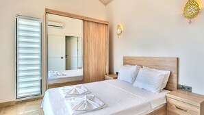 Ein Schlafzimmer mit einem Bett, einem Nachttisch, einem Holzschrank und einer Schiebetür.