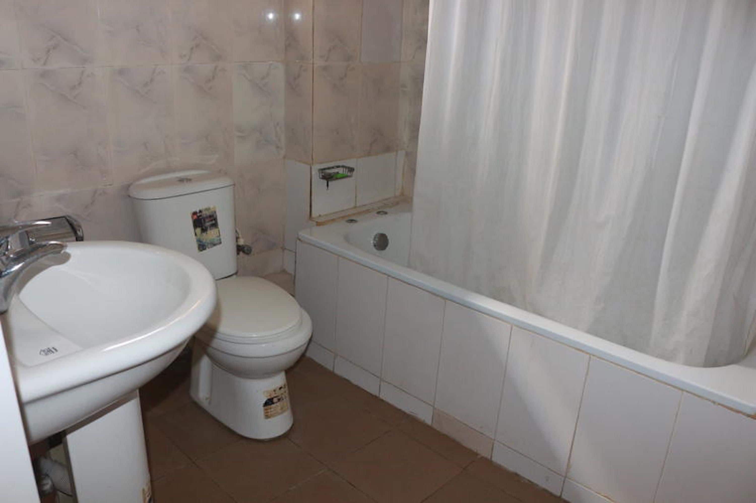 Une salle de bain avec des toilettes, un lavabo et une baignoire.