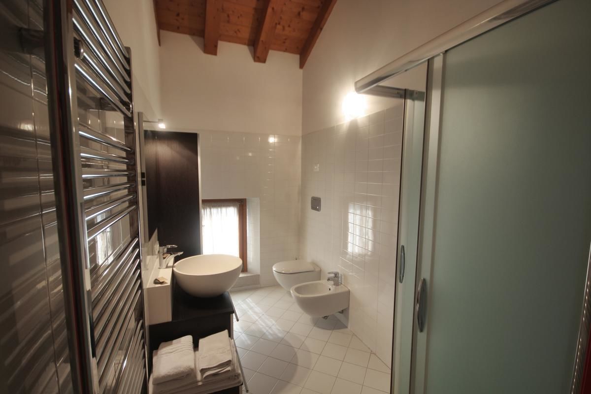 Een moderne badkamer met een grote spiegel, een wastafel, een douchecel en een toilet.