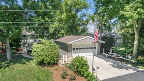 A residential garage with a white garage door, a small porch, and a mailbox.