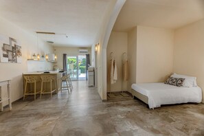 Une chambre dâhĂŽtel moderne Ă©quipĂ©e dâun lit, dâune petite kitchenette et dâun coin repas avec des chaises.