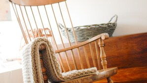 A wooden chair with a knitted blanket draped over it. - The Saddle and Stable Rooms (Penzance)