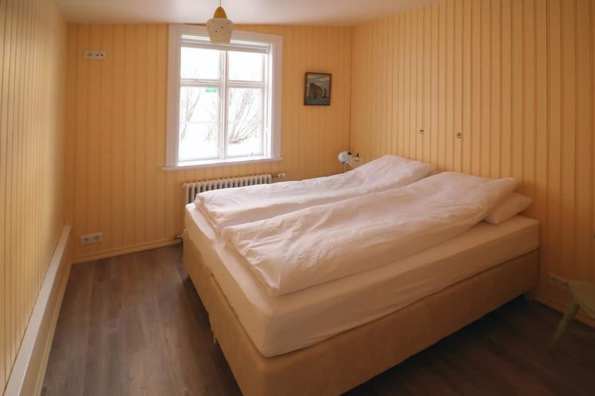 A room with a single bed, a window, and a radiator.