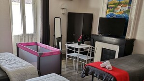 Une chambre d’hôtel avec un lit, une petite table et une chaise, un téléviseur et un tableau au mur.