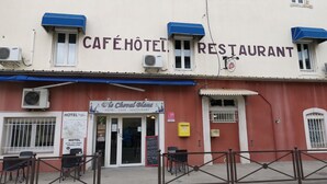 Un bâtiment sur lequel on peut lire l’inscription « CAFÉ HÔTEL RESTAURANT » et « Le Cheval Blanc HÔTEL CAFÉ RESTAURANT ».