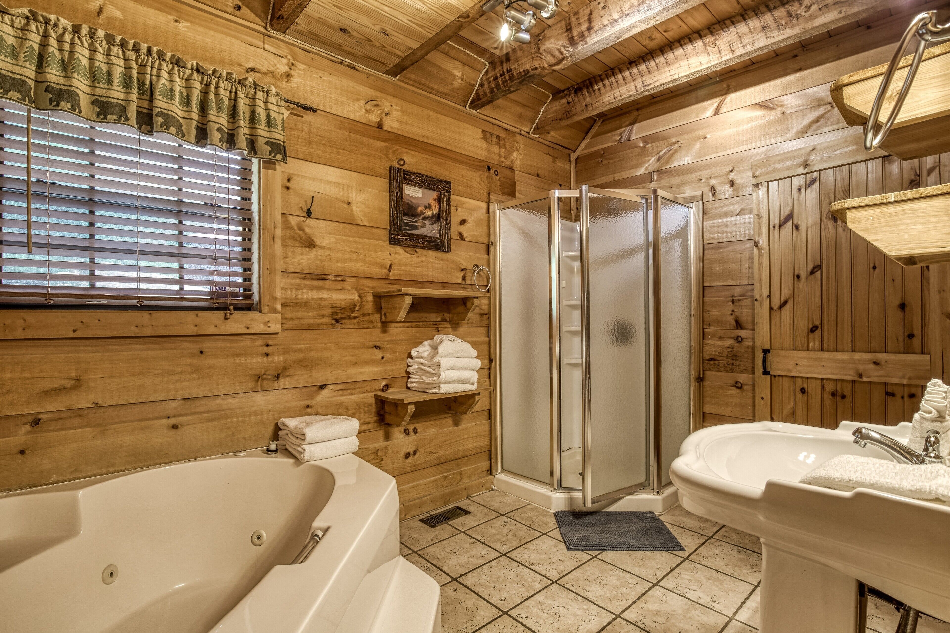 Ein Badezimmer einer Holzhütte mit Badewanne, Dusche und Waschbecken.
