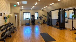 A gym with wooden floors, exercise equipment, and large windows. - Bashults Gård (Jonkoping)