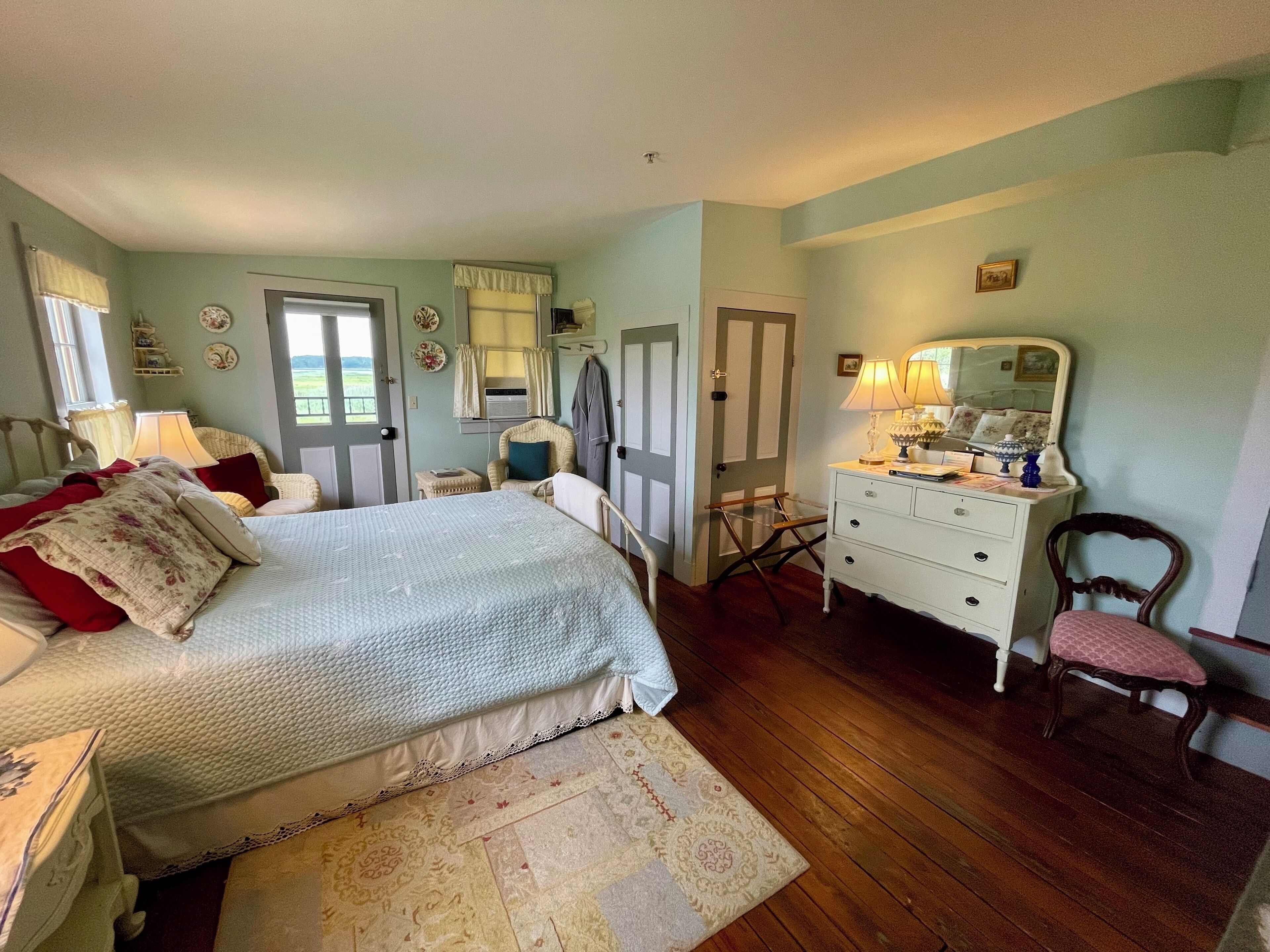 A bedroom with a bed, dresser, chair, and a mirror.