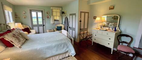 A bedroom with a bed, dresser, chair, and a mirror.