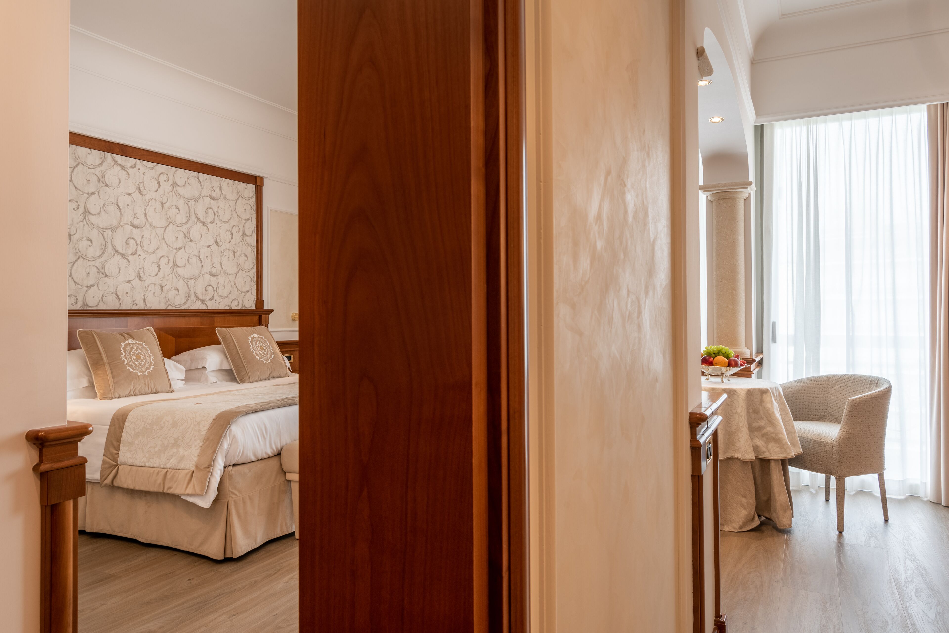 Una habitación de hotel con cama, una mesa de comedor con sillas y vistas al exterior.