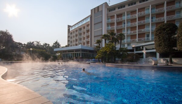 Relax by the pool surrounded by lush gardens and palm trees.