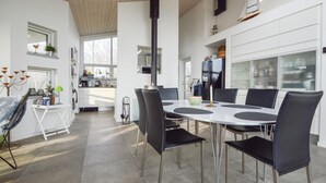 A modern kitchen with a central island, white cabinetry, and a large window. - 3 bedroom amazing home in Haderslev (Haderslev)