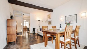 A dining area with a wooden table and chairs, a white rug, and a wooden cabinet. - Gorgeous home in CERET with house a mountain view (CERET)