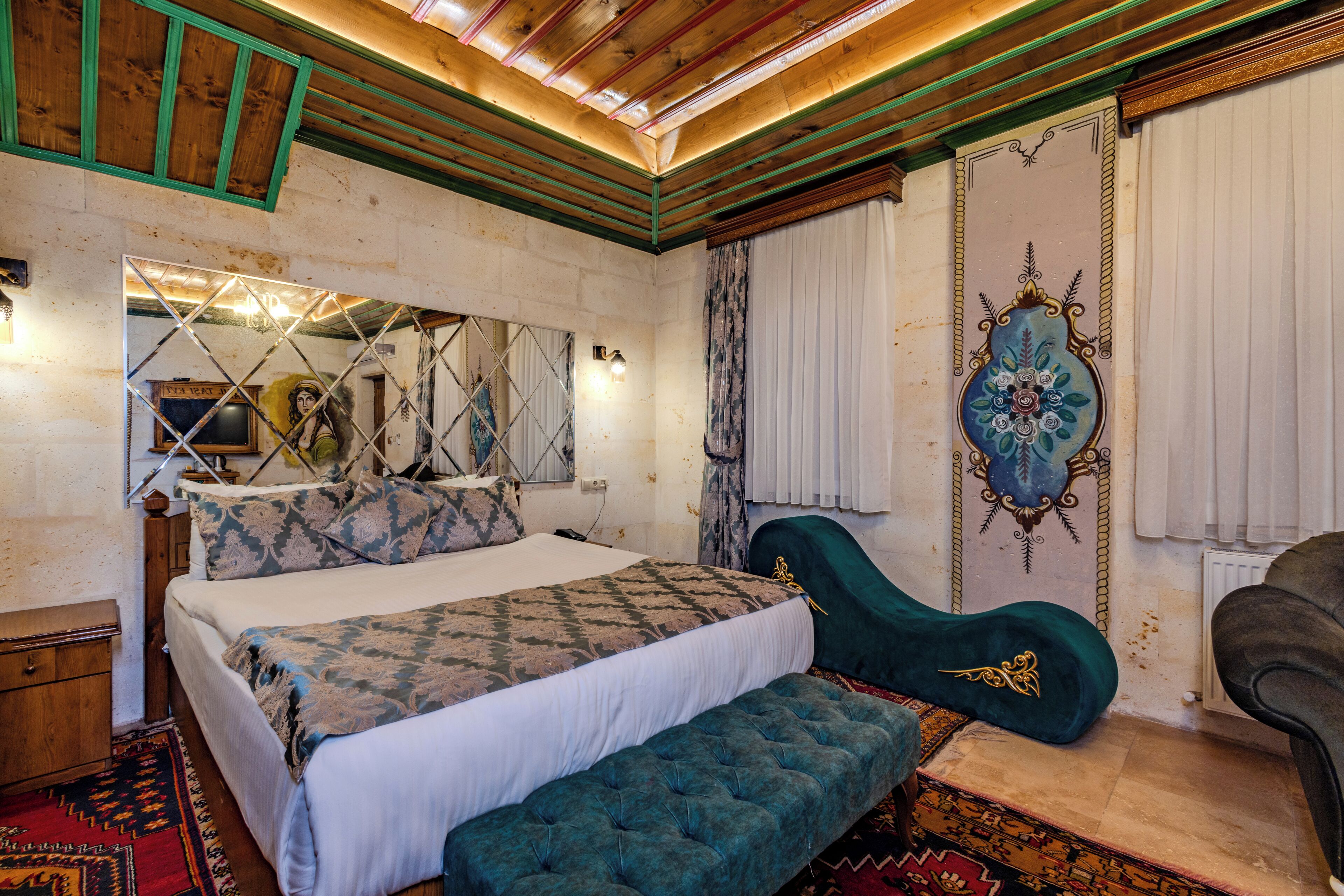 Une chambre à coucher comprenant un lit, un banc, une chaise, un miroir et un panneau décoratif mural.