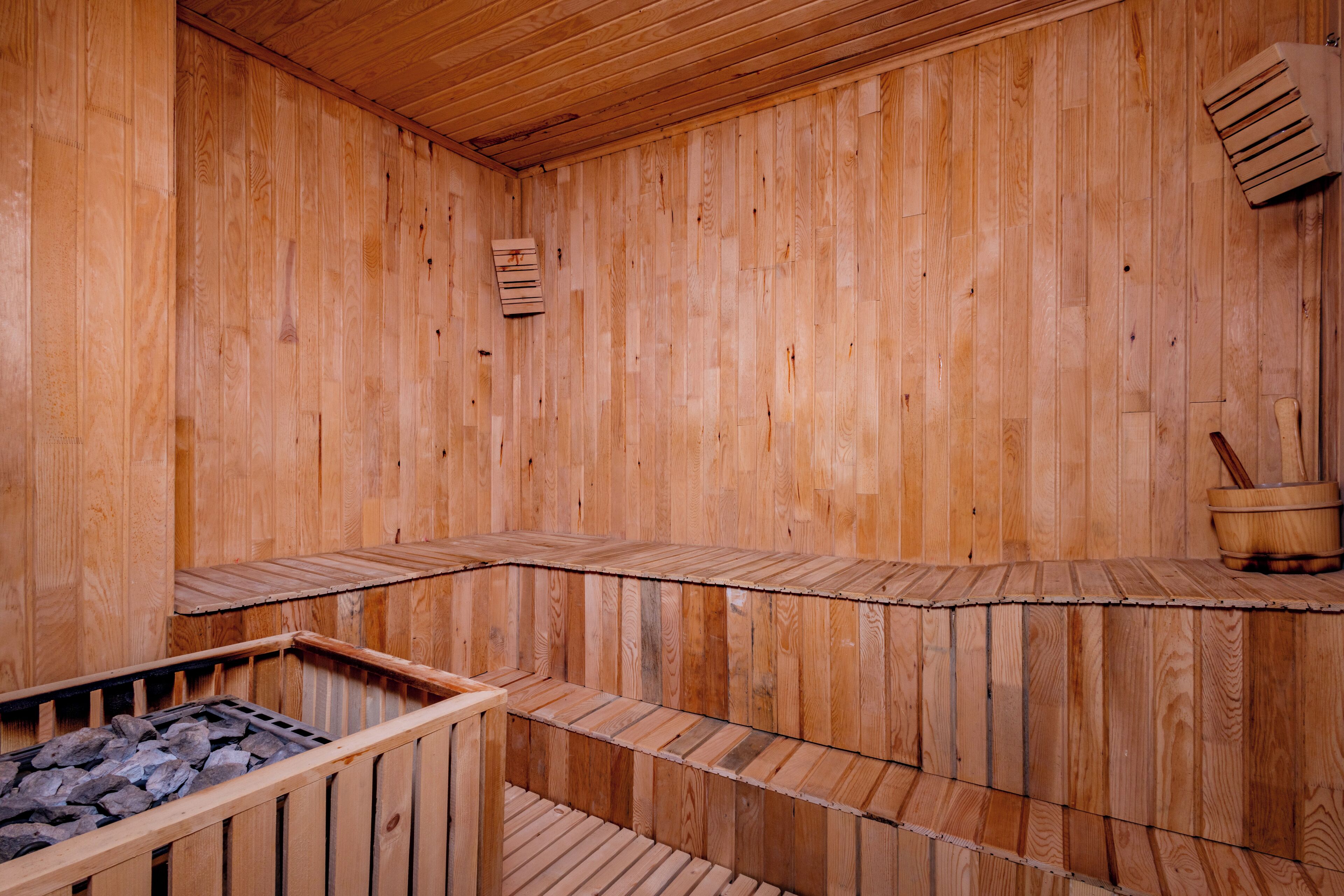 A wooden sauna with benches and a stone basin.