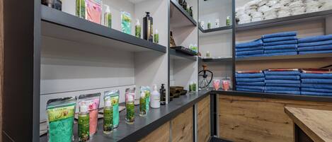 A bathroom with shelves holding toiletries and towels.