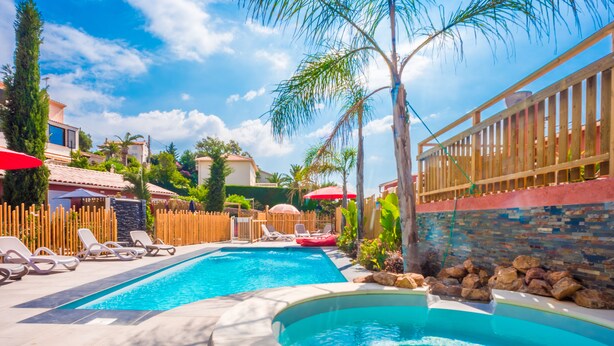 A swimming pool with lounge chairs and a wooden fence. - Les Flots Bleus (Saint-Raphael)