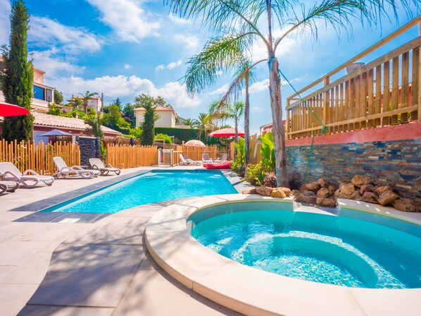 Een seizoensgebonden buitenzwembad en parasols bij het zwembad