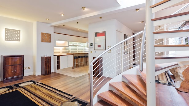 A modern interior with a wooden staircase, a kitchen area, and a dining space. - The Brendan Gleeson Suite - hiphipstay (Dublin)