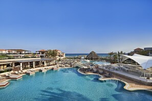 A resort with a large pool, sun loungers, umbrellas, and a view of the ocean. - Atlantica Caldera Palace - All Inclusive (Hersonissos)