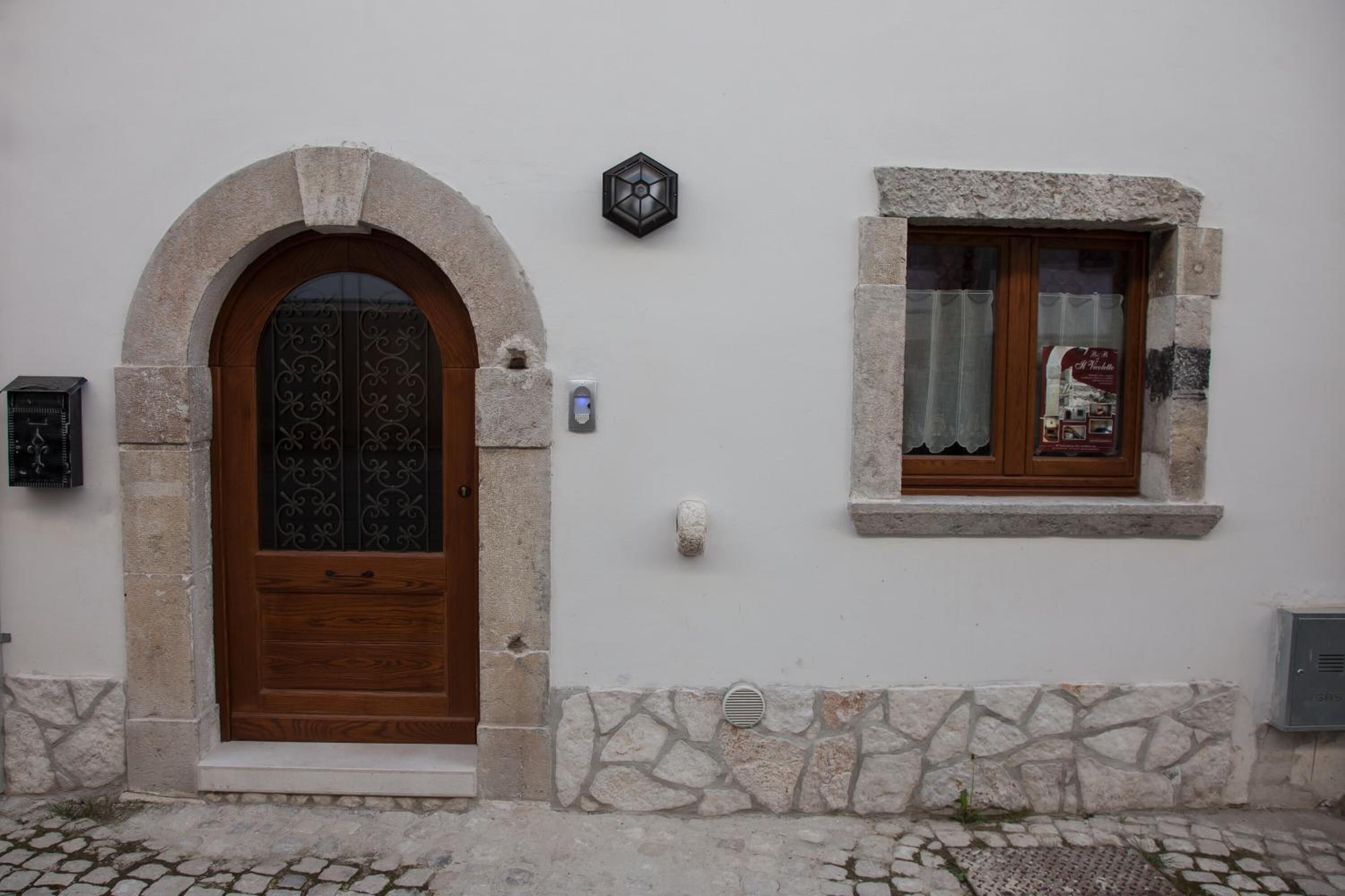 Eine Fassade aus Stein mit einer Holztür und einem Fenster.