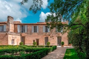 A historic building with a symmetrical facade, large windows, and a well-maintained garden. - Les Maisons de l'Hôtel Particulier (Maussane-les-Alpilles)