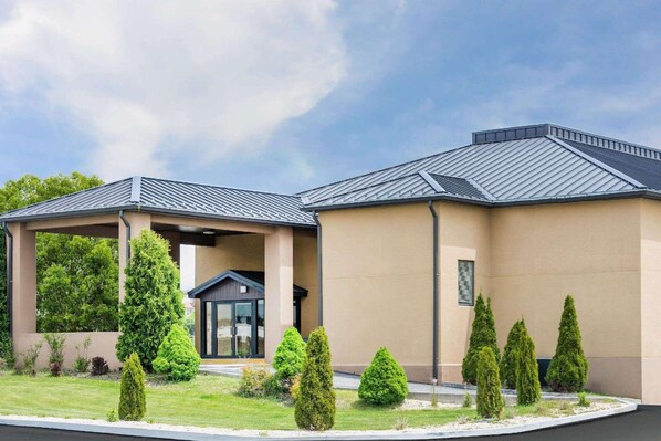 A modern building with a covered entrance and a well-maintained lawn. - Wingate by Wyndham Somerset (Somerset)