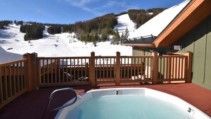 Een jacuzzi met uitzicht op een besneeuwde helling.