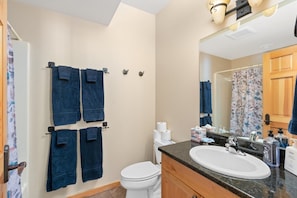 A bathroom with a toilet, sink, and towel rack.