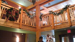 A wooden interior with a Christmas tree, a chandelier, and an exit sign. - Morning Eagle #109 1 Bedroom Condo (Whitefish)