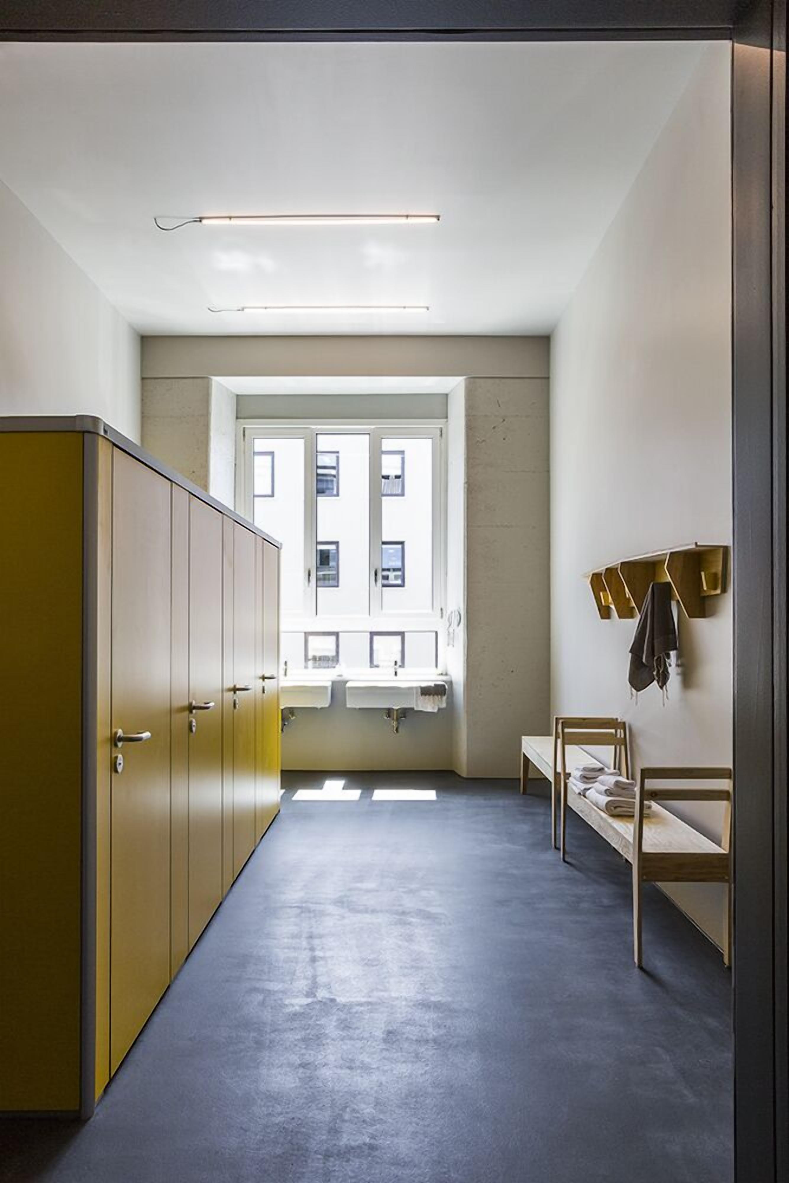 A narrow hallway with a window, a bed, and a wardrobe.