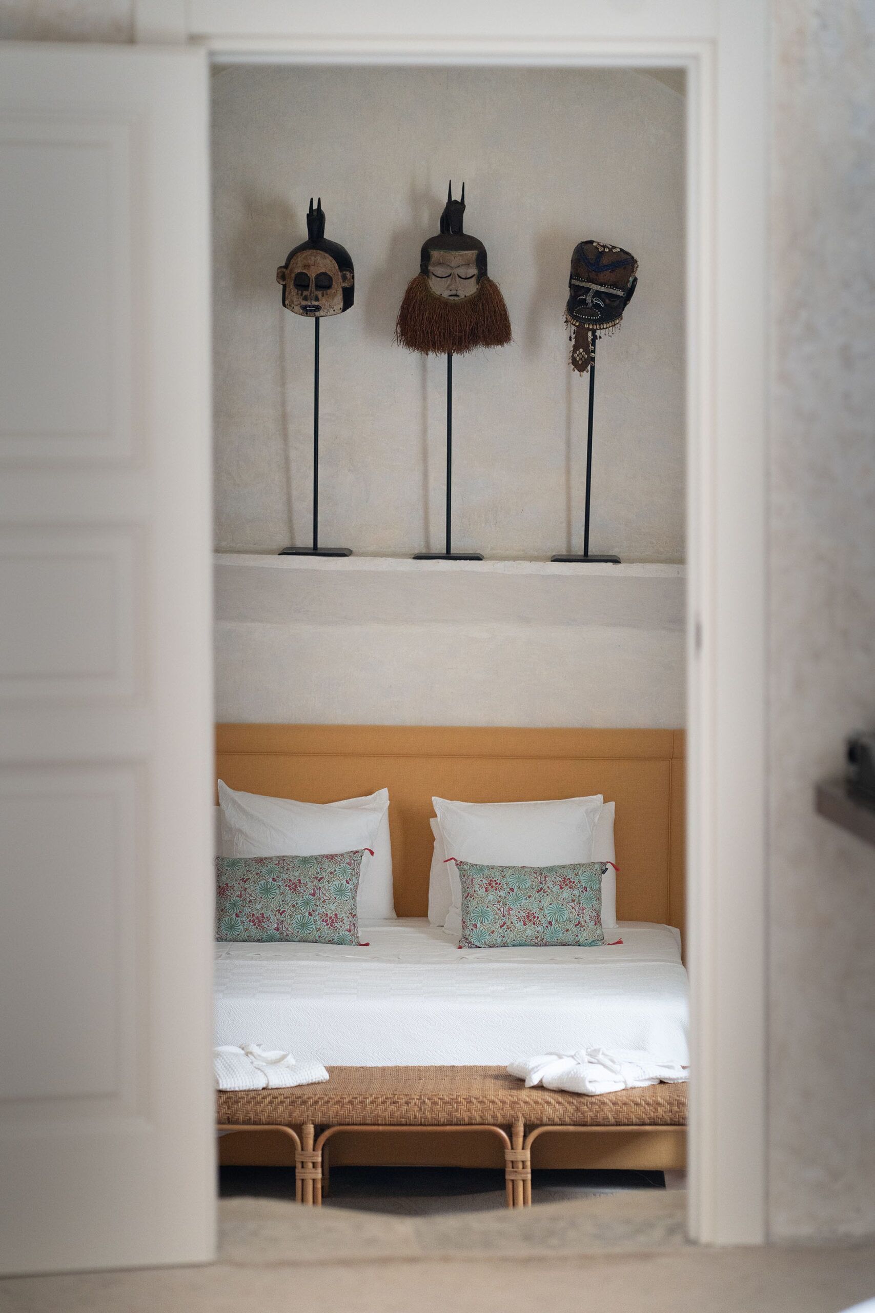 Ein Schlafzimmer mit einem Bett, Kissen und einem Regal mit drei Dekorationsobjekten.