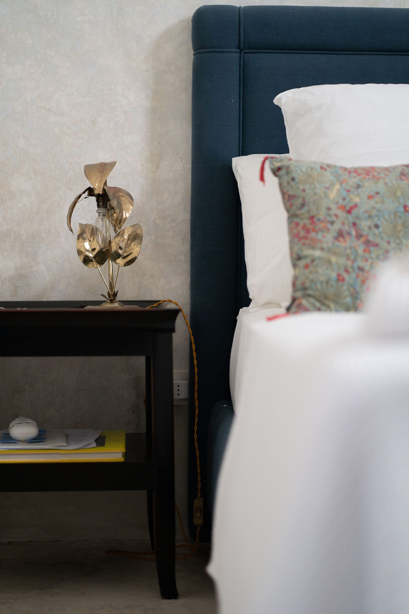 Un dormitorio con cama, mesita de noche y lámpara.