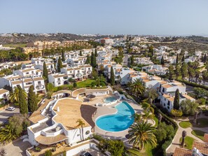 A resort with a large pool, white buildings, and palm trees. - Apt. 89-A São Rafael by HelloVacations (Albufeira)