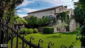 A stone building with a staircase leading to the entrance, surrounded by greenery. - Villa Lav (Bale)