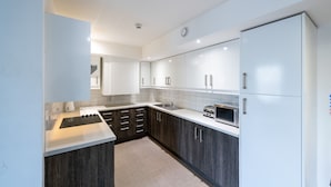 A modern kitchen with white cabinets, a built-in oven, and a microwave. - University of Bath City Accommodation (Bath)