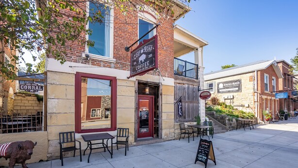 A brick building with a red door and outdoor seating area.