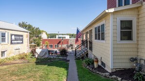 A pathway leading to a building with a red roof and a sign for 'Emma's Antiques & Collectibles'.