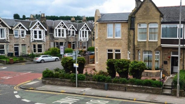 A row of terraced houses with a bus lane on the road. - Drumorne Guest House (Edinburgh)