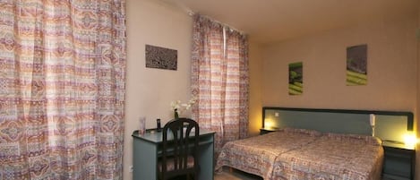 Un dormitorio con dos camas, un escritorio y una silla.