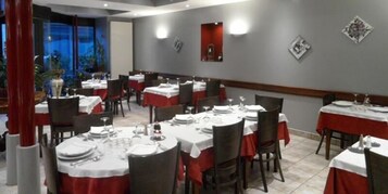 A restaurant with multiple tables set for dining, featuring a red and white color scheme.