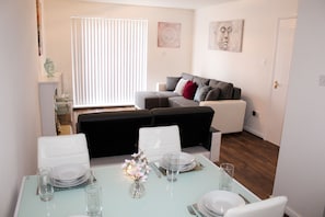 Enjoy a stylish dining experience in this modern living space, featuring a contemporary sofa and dining table set for a perfect meal.
