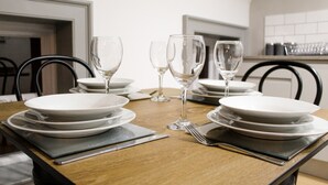 Une table à manger dressée avec des assiettes, des verres et des couverts.